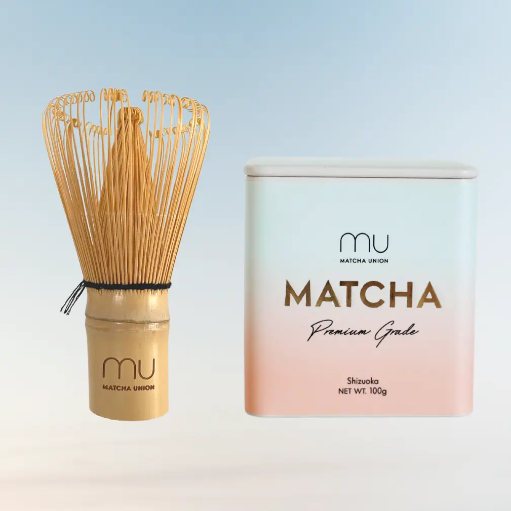 Bamboo matcha whisk beside a Matcha Union Premium Grade matcha tin