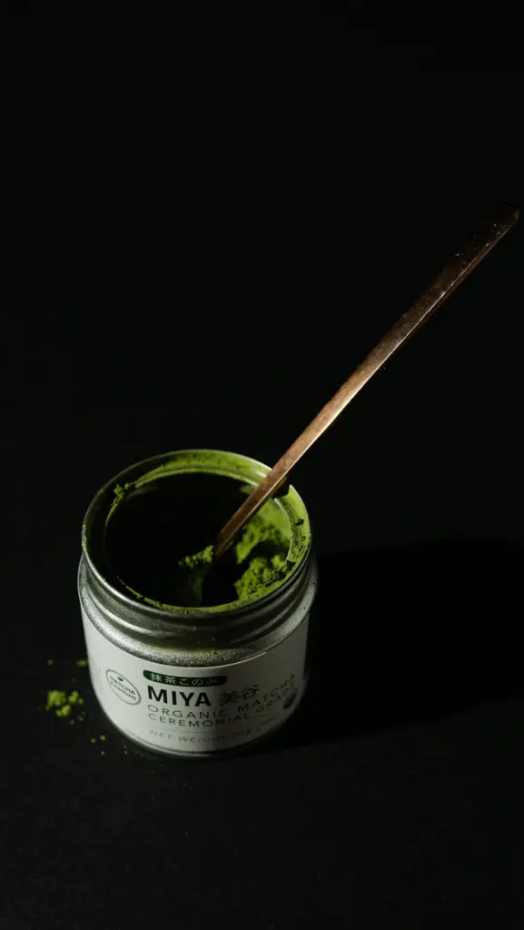 Open Miya matcha tin filled with green powder and a metal spoon