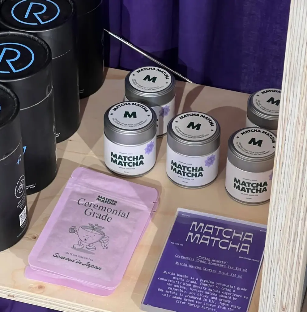 Pink ceremonial grade matcha pouches and branded tins on a display shelf
