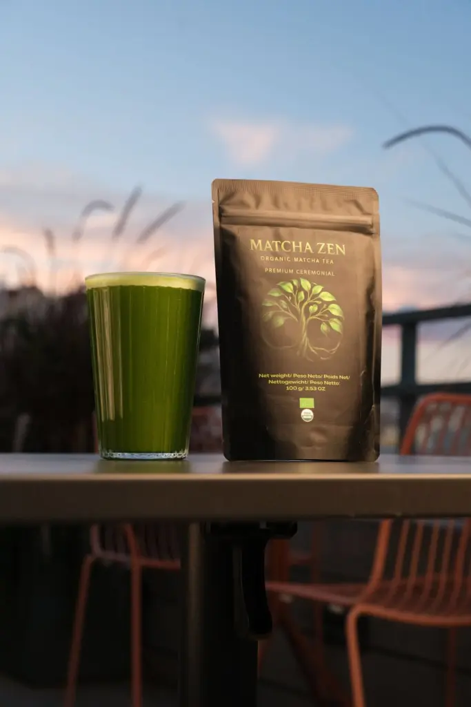Matcha Zen ceremonial pouch beside a tall glass of foamy green tea