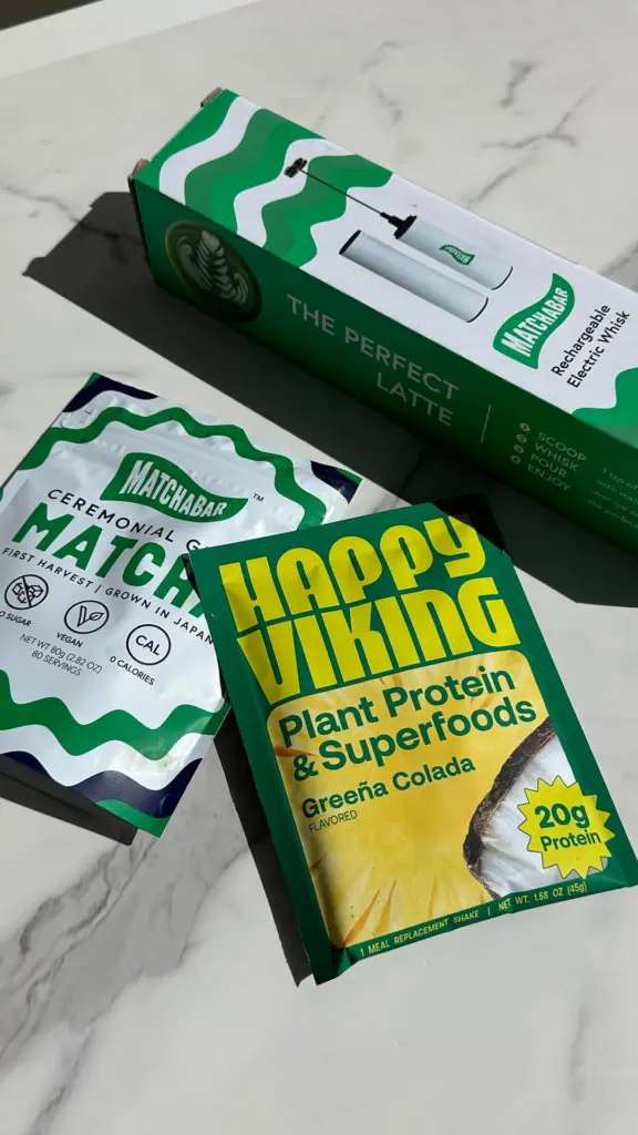 MatchaBar ceremonial matcha pouch and electric whisk box beside a Happy Viking packet