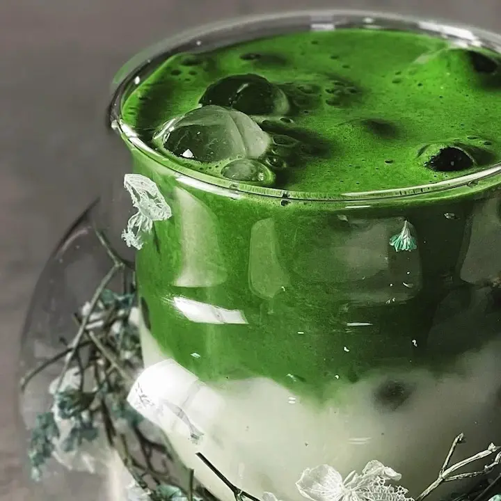 Layered green and white iced drink decorated with small flowers