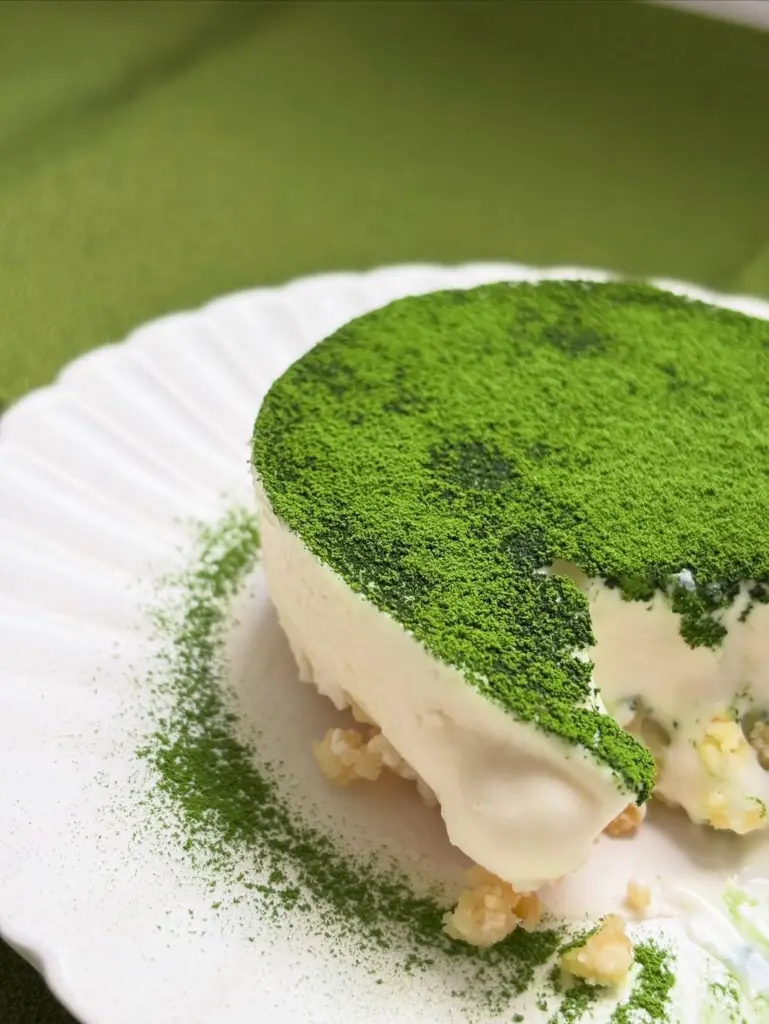 Round green powder-dusted dessert with one slice removed