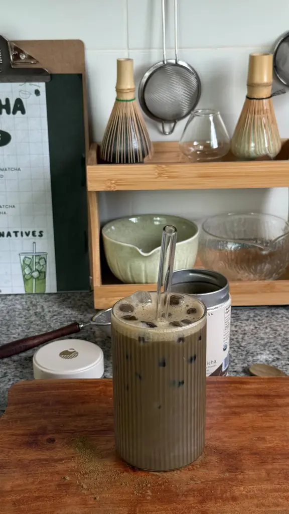 Iced green tea drink with foam in a tall ribbed glass
