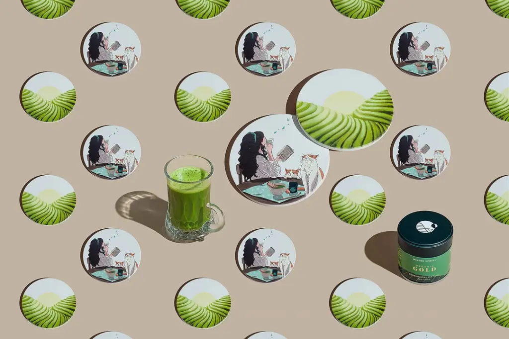 Glass mug of bright green tea and Midori Spring Organic Gold tin among illustrated circles