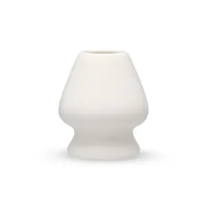 White porcelain matcha whisk holder with a rounded body and narrow base