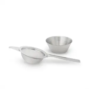 Fine-mesh matcha sifter with a long handle beside a small bowl