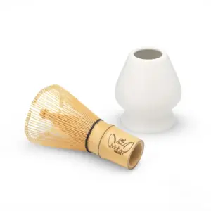 Bamboo matcha whisk beside a white hourglass-shaped holder