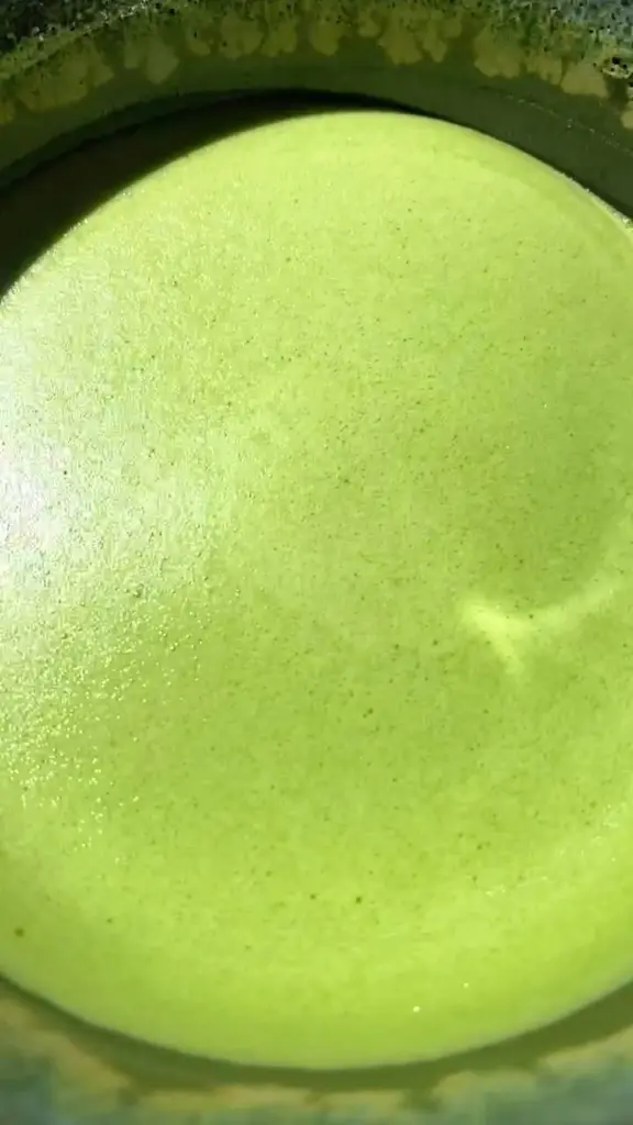 Close-up of bright green matcha with a fine layer of foam