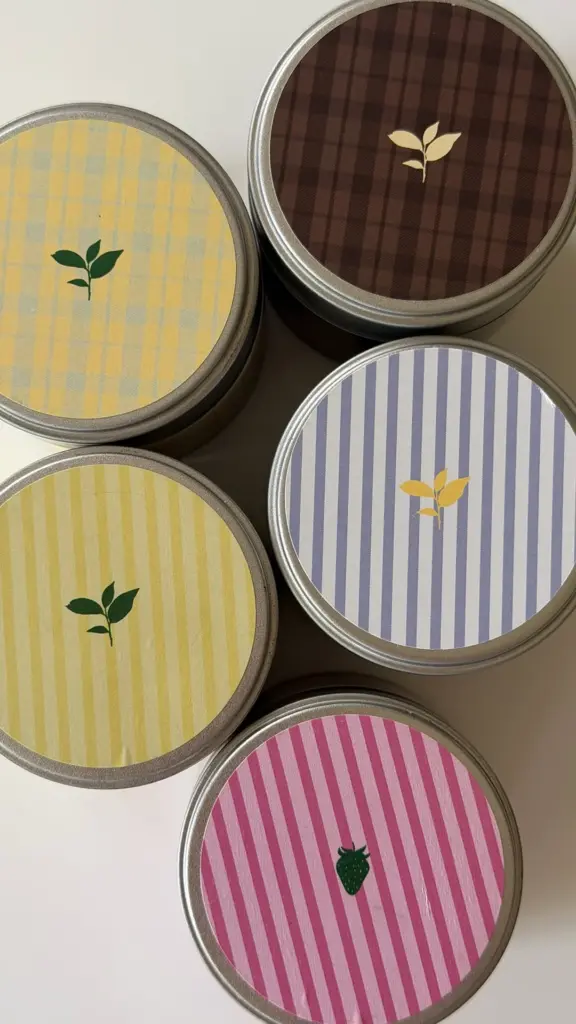 Five round tins with colorful plaid and striped lids