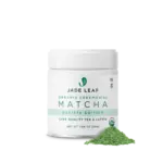 White Jade Leaf Organic Ceremonial Barista Matcha jar beside a pile of green matcha powder