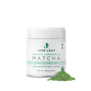 White Jade Leaf Organic Ceremonial Barista Matcha jar beside a pile of green matcha powder