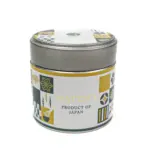 Silver matcha tin with a white, gold, and dark green patterned label reading “Matcha, Product of Japan”