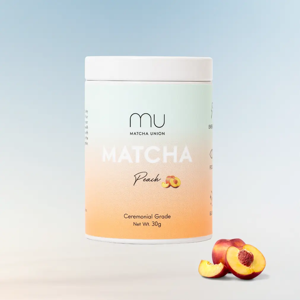 Matcha Union Peach Matcha 30 g tin beside a whole peach, peach half, and slice