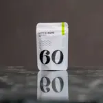 White Matcha Crew No. 60 Premium Matcha 40 g pouch reflected on a dark tabletop