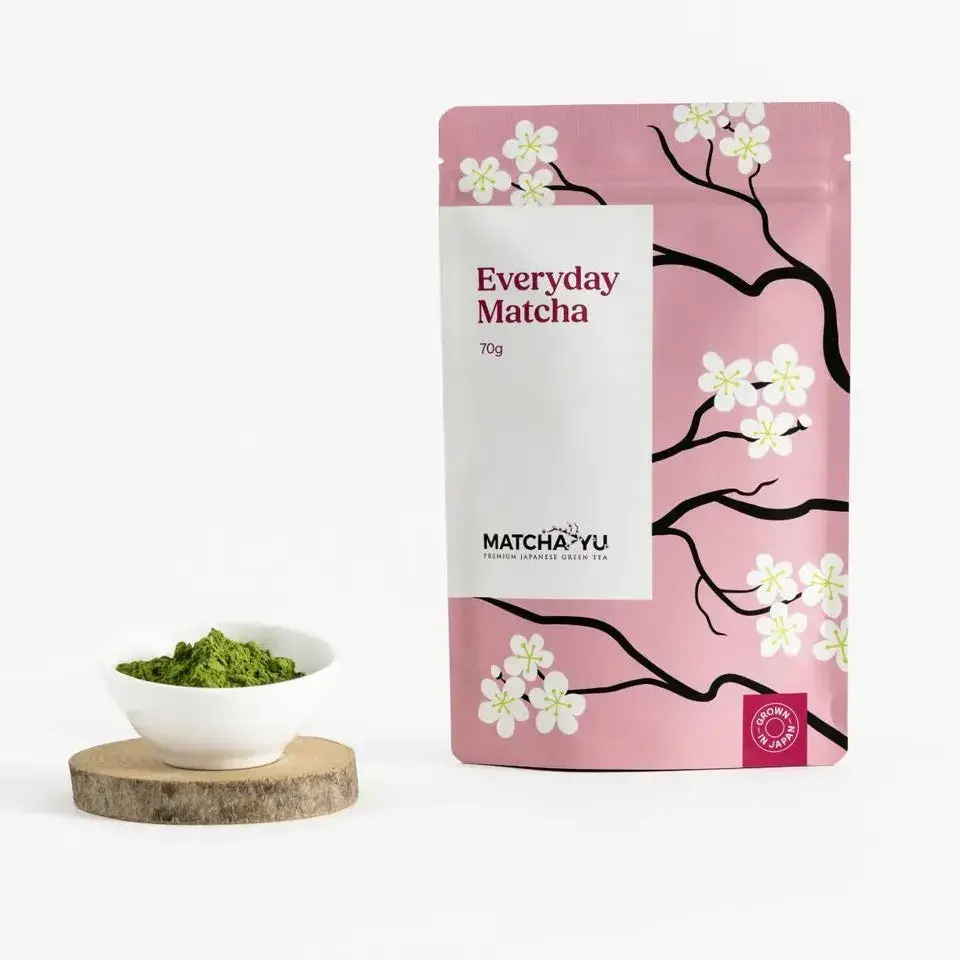 Pink Matcha Yu Everyday Matcha 70g pouch beside a bowl of matcha powder