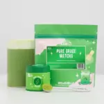 Green Bird & Blend matcha pouch and tin beside a glass of prepared matcha and a spoonful of powder