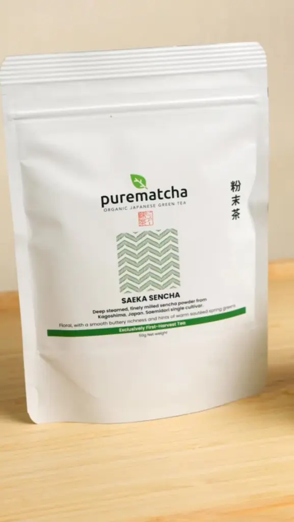 White PureMatcha Saeka Sencha pouch standing on a wooden surface