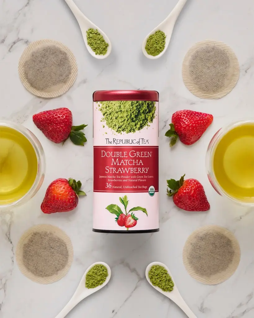 Double Green Matcha Strawberry tin surrounded by strawberries, tea, matcha powder, and tea bags
