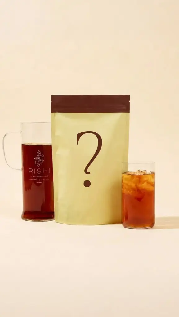 Question-mark package between a Rishi Tea pitcher and a glass of iced amber tea