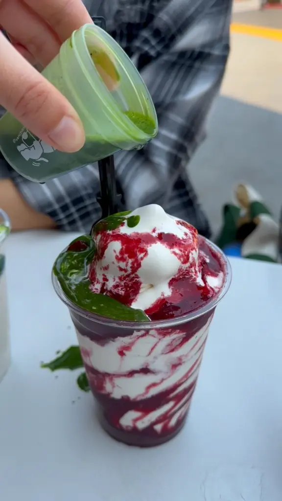 Dark green sauce poured over a red berry and cream dessert