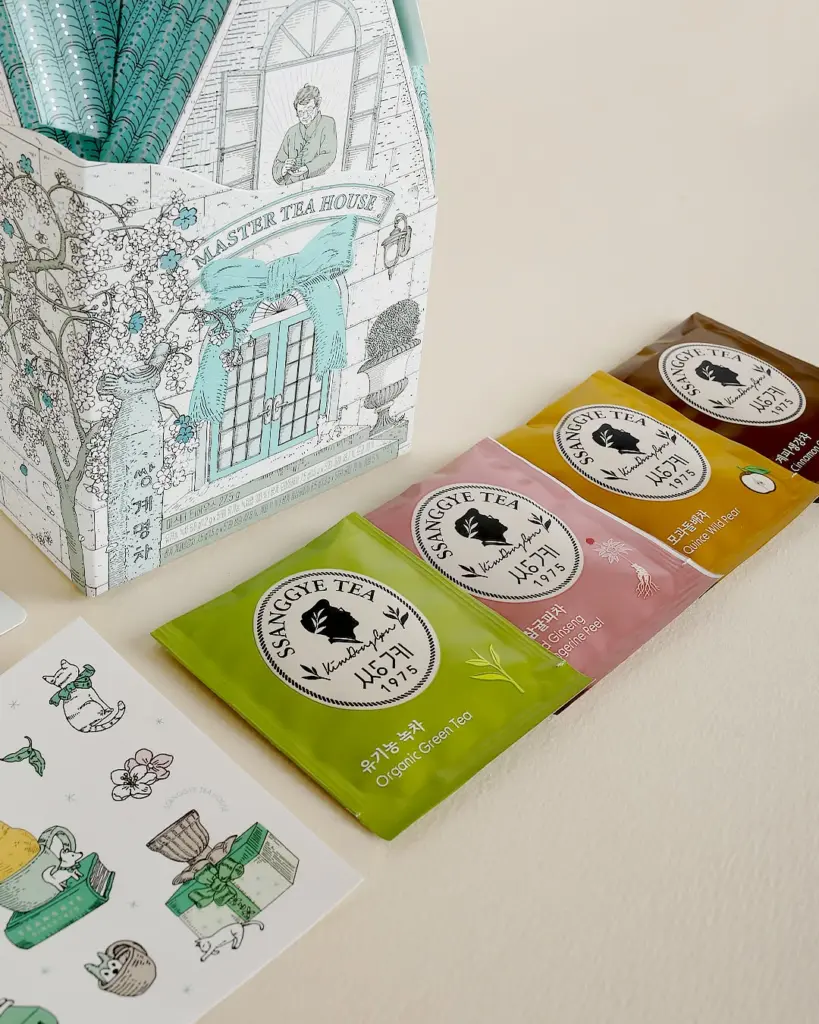 Green, pink, yellow, and brown Ssanggye Tea sachets beside an illustrated box