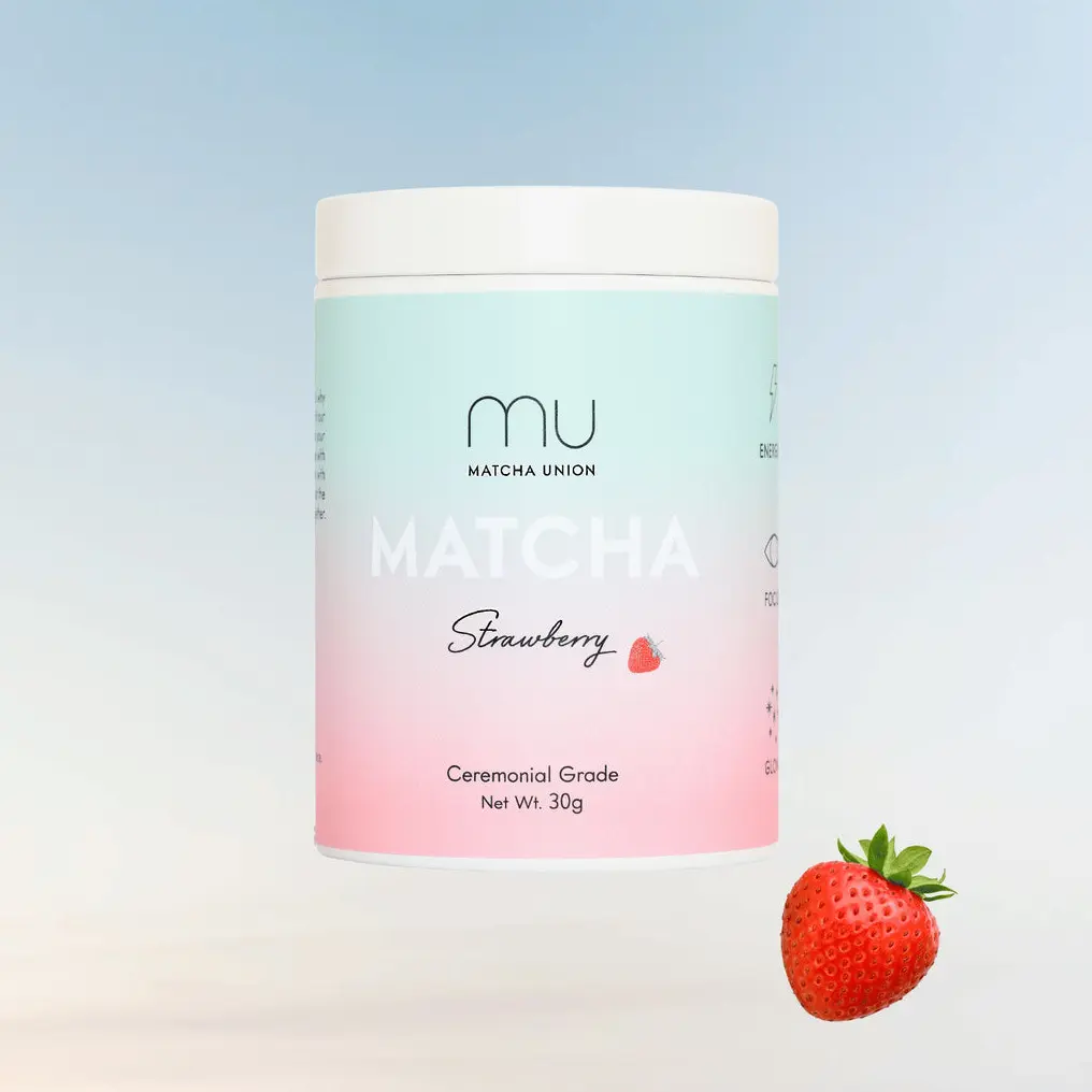 Pastel blue and pink Matcha Union Strawberry Matcha tin beside a strawberry