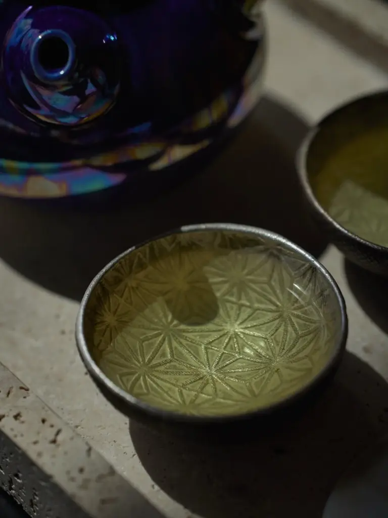 Pale golden tea in a ceramic cup with a geometric pattern