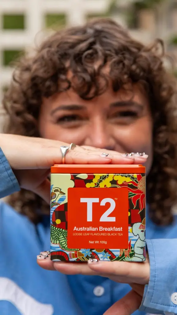 Person holding a colorful T2 Australian Breakfast tea tin
