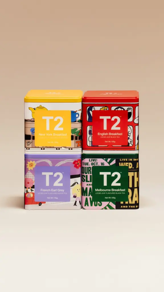 Four illustrated T2 tea tins stacked against a beige background