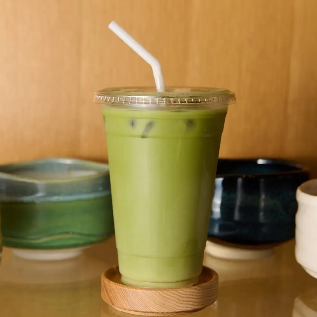 Iced green drink in a clear cup with a straw