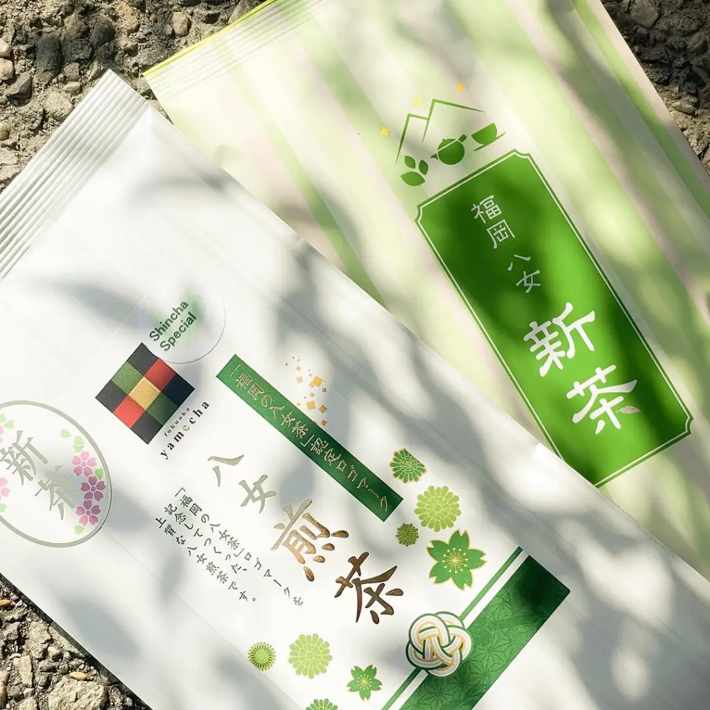 Two decorative Shincha tea packages on sunlit gravel