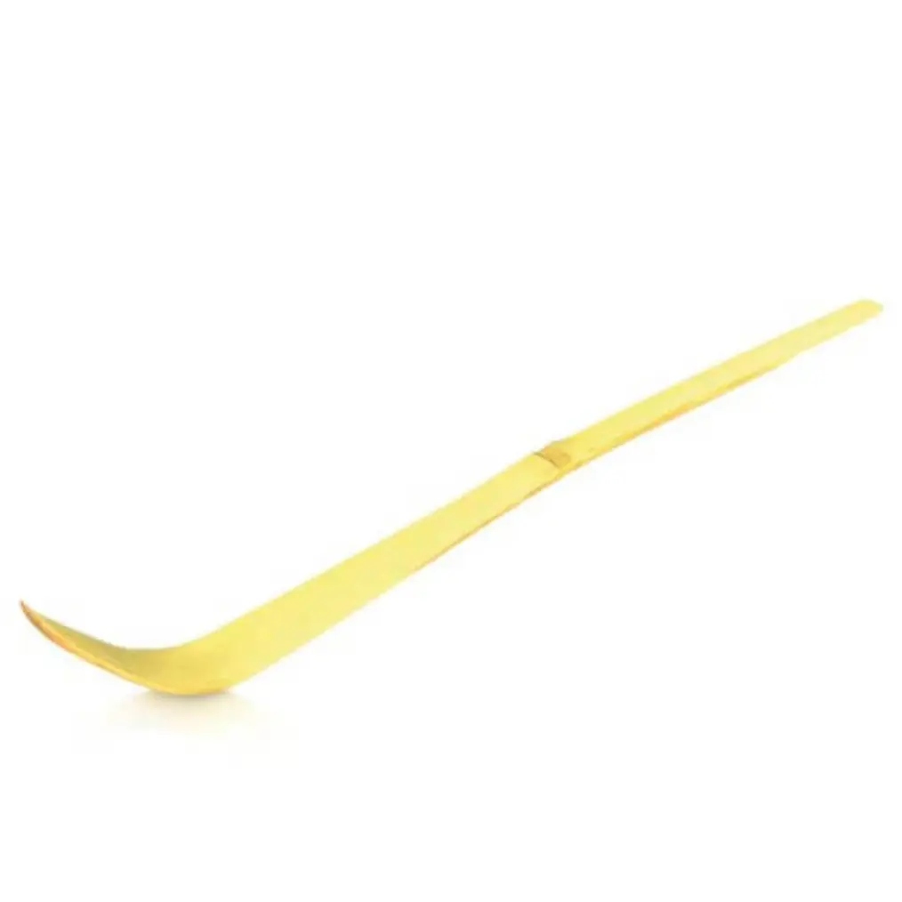 Pale bamboo chashaku with a curved scoop on a white background