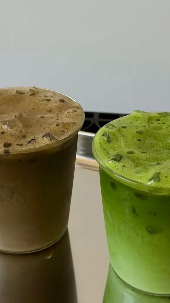 Foamy green and brown iced drinks in clear cups