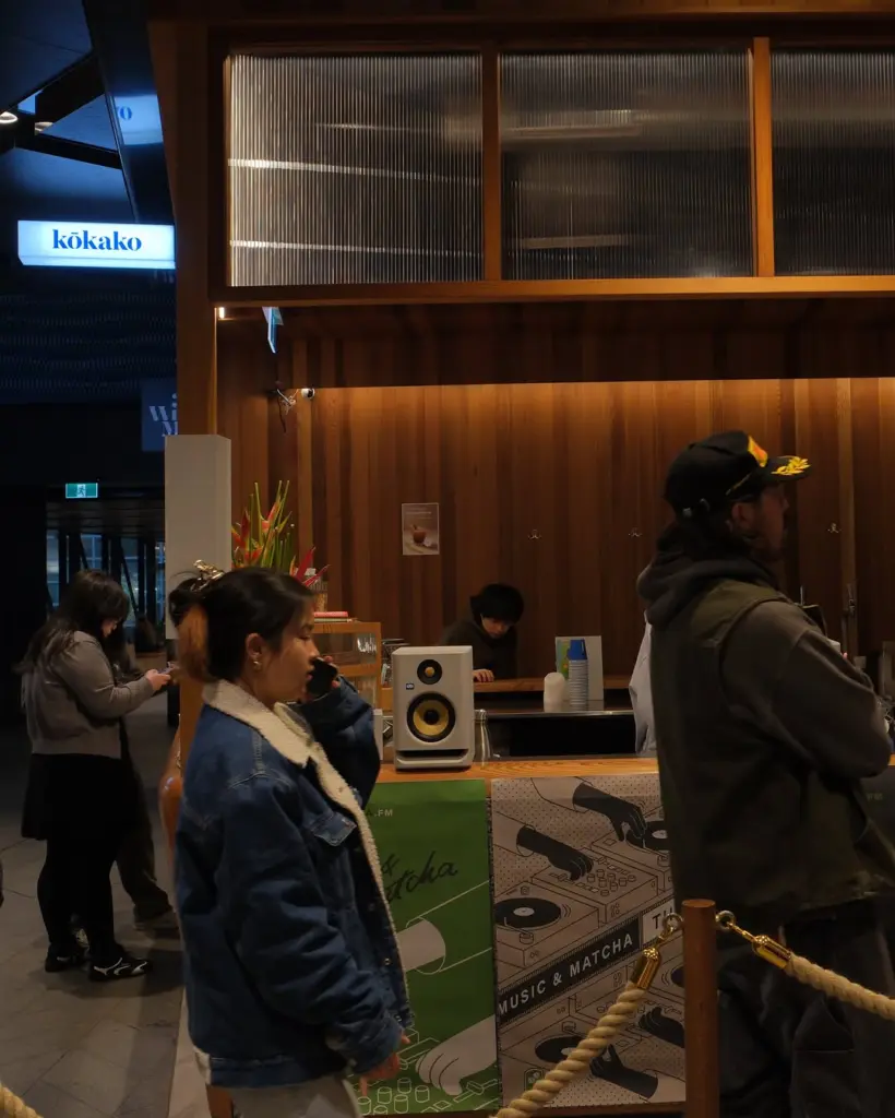 Customers beside a counter with a speaker and illustrated music graphics