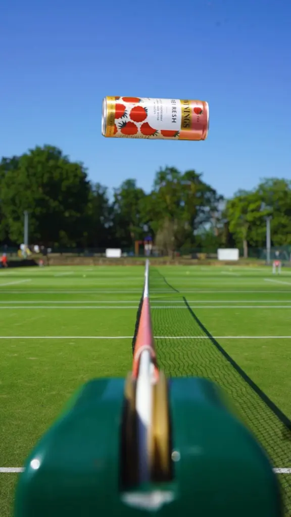 Twinings Refresh can suspended above a tennis net on a sunny grass court