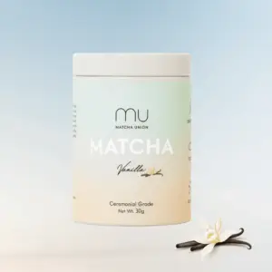 Matcha Union Vanilla Matcha 30 g tin beside vanilla flowers and pods