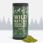 Green Wild Matcha ceremonial tea tin beside a mound of green powder